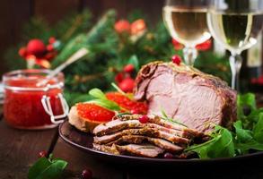 Kerstmis gebakken ham en rood kaviaar, geserveerd Aan de oud houten tafel. foto