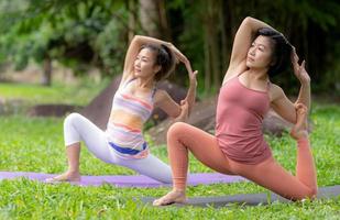 jong vrouw yoga buitenshuis Aan de gazon. foto