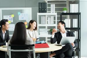 een groep van jong Aziatisch ondernemers. top beheer is vergadering naar recensie voorraad investering gegevens van de team in een vergadering kamer met natuurlijk licht foto