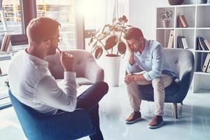 gevoel droefheid. jong gefrustreerd Mens oplossen zijn mentaal problemen terwijl hebben behandeling sessie met psycholoog foto