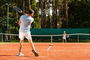 bij elkaar passen punt. vol lengte van Mens en vrouw spelen tennis Aan tennis rechtbank foto