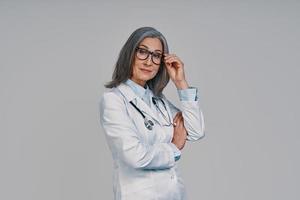 volwassen mooi vrouw dokter op zoek Bij camera en glimlachen foto