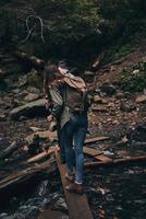 Nee moeilijkheden voor hen. vol lengte achterzijde visie van jong paar wandelen samen in de bossen terwijl genieten van hun reizen foto