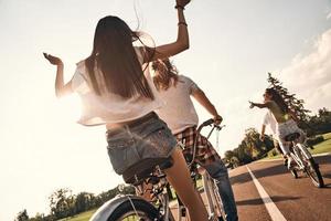 gelukkig naar worden in de omgeving van. achterzijde visie van jong mensen in gewoontjes slijtage wielersport samen terwijl uitgeven zorgeloos tijd buitenshuis foto