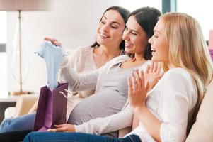 presenteert voor jong moeder. gelukkig jong zwanger vrouw ontvangen cadeaus van haar vrienden Aan baby douche partij foto