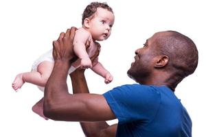 de het beste geschenk van leven. kant visie van gelukkig jong Afrikaanse Mens Holding zijn weinig baby en op zoek Bij hem met glimlach terwijl staand geïsoleerd Aan wit foto