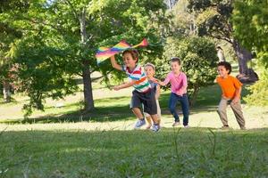 kinderen spelen met vlieger in park foto
