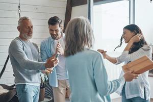 modern senior ouders vergadering jong paar binnen de huis foto