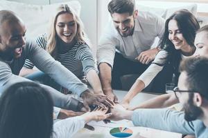 wij zijn de Super goed team groep van gelukkig bedrijf mensen Holding handen samen terwijl zittend in de omgeving van de bureau foto