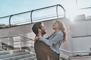 liefde is in de lucht. knap Mens draag- jong aantrekkelijk vrouw terwijl uitgeven tijd buitenshuis foto