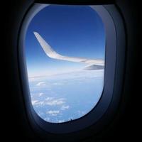 zicht op blauwe lucht vanuit vliegtuigraam (2)