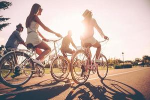 vrijheid is in hun aderen. laag hoek visie van jong mensen rijden fietsen langs een weg en op zoek gelukkig foto