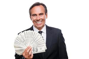 geld is een stroom. portret van zelfverzekerd volwassen Mens in formele kleding Holding geld en glimlachen terwijl staand tegen wit achtergrond foto