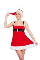 mooi de kerstman meisje. vrolijk jong vrouw in de kerstman kostuum op zoek Bij weg terwijl poseren tegen wit achtergrond foto