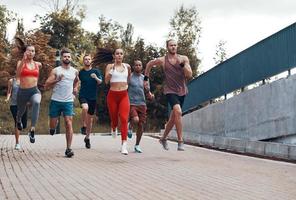 vol lengte van mensen in sport- kleding jogging terwijl oefenen buitenshuis foto