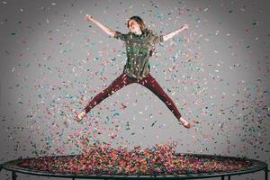 Leuk vinden een super ster. in de lucht schot van mooi jong vrouw jumping Aan trampoline met confetti allemaal in de omgeving van haar foto