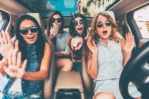 hou op vier jong Dames gebaren en op zoek doodsbang terwijl zittend in auto samen foto