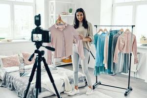 vol lengte van mooi jong vrouw in gewoontjes kleding maken sociaal media video terwijl uitgeven tijd Bij huis foto