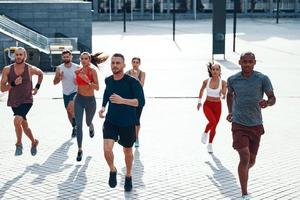 top visie van mensen in sport- kleding jogging terwijl oefenen Aan de trottoir buitenshuis foto