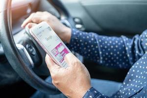 Holding mobiel telefoon in auto naar communicatie met familie en vrienden. foto