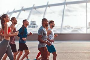 groep van jong mensen in sport- kleding jogging samen buitenshuis foto