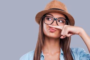 speels stijl. detailopname portret van een jong vrouw Holding een vinger omhoog naar haar neus- terwijl op zoek weg foto