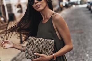 altijd in stijl. detailopname van jong vrouw Holding haar handtas terwijl staand buitenshuis foto