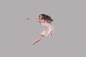 vrij springen. studio schot van aantrekkelijk jong vrouw zweven in lucht foto