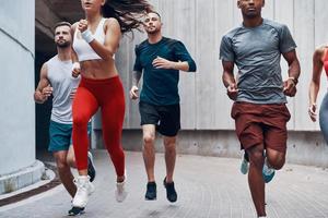 groep van jong mensen in sport- kleding jogging terwijl oefenen buitenshuis foto