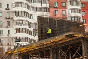 bouw plaats. de arbeider presteert werk Bij hoogte foto