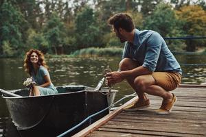 echt liefde. gelukkig jong paar krijgen klaar naar rij een boot terwijl genieten van hun datum buitenshuis foto