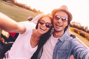 wij liefde selfie mooi jong paar bonding naar elk andere en leunend Bij hun oppakken vrachtauto terwijl maken selfie foto