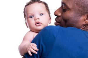 vader met weinig baby. achterzijde visie van jong Afrikaanse Mens Holding zijn weinig baby en glimlachen terwijl staand geïsoleerd Aan wit foto