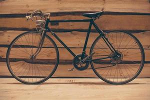 retro gestileerd fiets. detailopname van retro gestileerd fiets staand tegen ruw houten muur foto