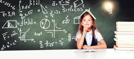 jong schattig meisje Bij schoolbord met licht lamp over- hoofd foto