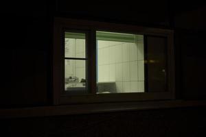 venster in gebouw. single venster. licht in donker interieur. glas in avond. foto