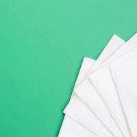 meerdere wit papier servetten liggen Aan een plastic groen achtergrond foto