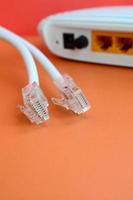 internet router en internet kabel pluggen liggen Aan een helder oranje achtergrond. items verplicht voor internet verbinding foto