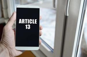 een Mens is Holding een smartphone met artikel 13 opschrift foto