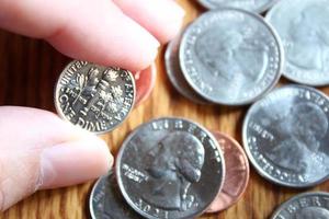 dollar munten en dollar rekeningen verspreide Aan een houten tafel, vlak leggen dollar munten. foto