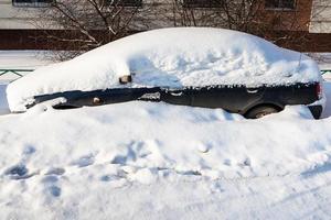 kant visie van zwart auto gedekt met sneeuw foto