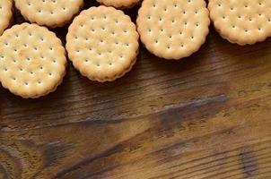 een ronde belegd broodje koekje met kokosnoot vulling leugens in groot hoeveelheden Aan een bruin houten oppervlak. foto van eetbaar behandelt Aan een houten achtergrond met kopiëren ruimte