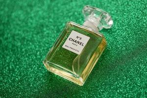 ternopil, Oekraïne - september 2, 2022 chanel aantal 5 eau première wereldwijd beroemd Frans parfum fles Aan glimmend schitteren achtergrond in groen kleuren foto