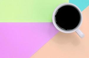 klein wit koffie kop Aan structuur achtergrond van mode pastel roze, blauw, koraal en limoen kleuren papier foto