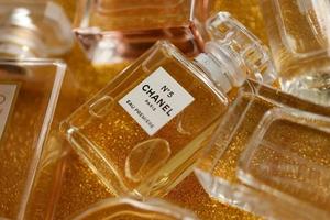 ternopil, Oekraïne - september 2, 2022 chanel aantal 5 eau première wereldwijd beroemd Frans parfum fles tussen andere parfums Aan glimmend schitteren achtergrond in geel kleuren foto