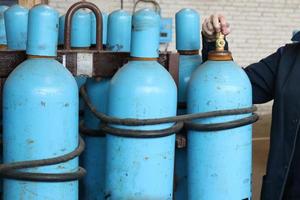 groot ijzer metaal blauw gas- cilinders met zuurstof, lucht, helium onder buitensporig intern druk naar op te slaan gecomprimeerd, vloeibaar gemaakt en opgelost onder druk gassen foto