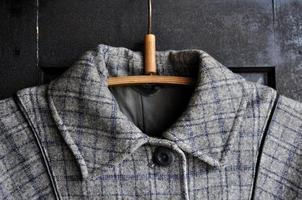 vintage grijze jassen kraag op de houten zwarte kledingkast foto
