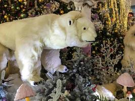 Kerstmis decoraties. een speelgoed- polair beer staat De volgende naar een kunstmatig Kerstmis boom. Kerstmis vooravond. gestileerde tentoonstelling voor bezoekers foto