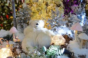 Kerstmis kaart met teddy beer, geschenk, versierd Kerstmis boom, fee lichten slinger foto