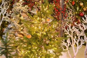 versierd Kerstmis boom Aan vervaagd, sprankelend en fee achtergrond foto